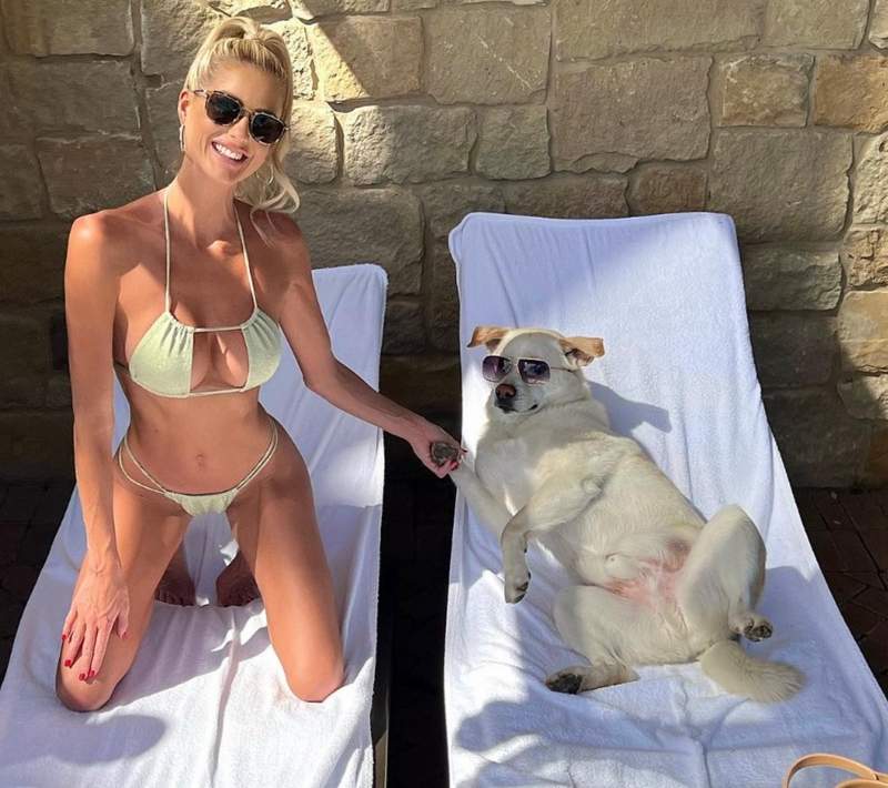 Emma Hernan posing in a bikini with her rescue dog Benny