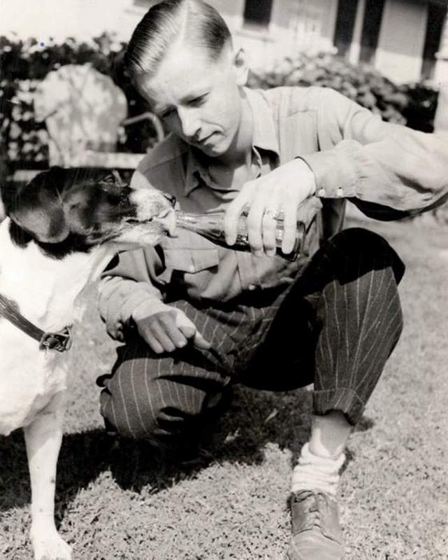 Charles Schulz giving root beer to his dog Spike, the inspiration for Snoopy